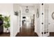 Inviting hallway showcasing hardwood floors, white walls, and an open view to other rooms at 10106 E 59Th Pl, Denver, CO 80238