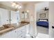 Shared bathroom with granite countertop, double sinks and white cabinets at 3100 Rockbridge Dr, Highlands Ranch, CO 80129