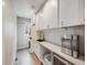 Laundry room with white cabinets, tile flooring and a utility sink at 3100 Rockbridge Dr, Highlands Ranch, CO 80129