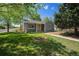 Charming single-story home featuring a well-maintained front yard, a bright yellow door, and mature trees at 1089 S Osceola St, Denver, CO 80219