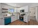Bright kitchen featuring white cabinets, modern countertops, stainless steel appliances, and hardwood floors at 1089 S Osceola St, Denver, CO 80219