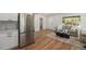 Open-concept design showcasing a stylish living room and kitchen with stainless steel appliances and wood flooring at 1089 S Osceola St, Denver, CO 80219