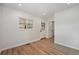 Bright living room featuring wood flooring, white trim and a charming white door at 1089 S Osceola St, Denver, CO 80219