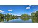 Scenic view of a tranquil pond surrounded by green trees under a blue sky with fluffy clouds at 1089 S Osceola St, Denver, CO 80219