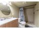 Bathroom featuring wood vanity with sink, large framed mirror, and shower-tub combination with tiled walls at 3632 Leyden St, Denver, CO 80207