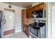 Well-lit kitchen with stainless steel appliances, dark cabinets and tile floors at 3632 Leyden St, Denver, CO 80207