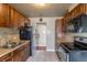 Traditional kitchen with dark wood cabinets, stainless steel appliances, and tile flooring at 3632 Leyden St, Denver, CO 80207