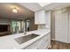 Open kitchen with white cabinets, a stylish sink, and a clear view into the living area at 447 S Memphis Way # 7, Aurora, CO 80017