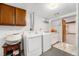 Spacious laundry room with side by side washer and dryer, cabinetry, and utility sink at 2321 Lima St, Aurora, CO 80010