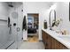 Contemporary bathroom featuring an open doorway, sleek glass shower, and dual vanities at 2376 S Bannock St, Denver, CO 80223