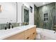 Modern bathroom featuring a double vanity, stylish lighting, and green tile shower at 2376 S Bannock St, Denver, CO 80223