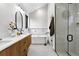 Stunning bathroom with dual sink vanity, modern tub, and glass enclosed shower at 2376 S Bannock St, Denver, CO 80223