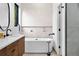 Bright bathroom featuring a soaking tub, modern vanity, and tiled accent wall at 2376 S Bannock St, Denver, CO 80223