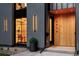 Close-up of a modern home's entrance featuring a wood door, black trim, and contemporary exterior lighting at 2376 S Bannock St, Denver, CO 80223