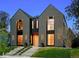 Modern home featuring a gray stucco exterior, large windows, black trim, and a landscaped front yard at 2376 S Bannock St, Denver, CO 80223