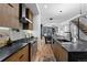 Modern kitchen featuring a black countertop island, stainless steel appliances, and hardwood floors at 2376 S Bannock St, Denver, CO 80223