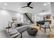 Open-concept living room with modern furniture, a unique staircase, and a seamless flow to the dining area at 2376 S Bannock St, Denver, CO 80223