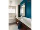 Modern bathroom features wood cabinets, dual sinks, a large mirror, and stylish blue accent wall at 4428 Perry St, Denver, CO 80212