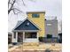 Unique two-story home with a yellow exterior, a rooftop deck, and manicured lawn at 4428 Perry St, Denver, CO 80212