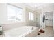 Beautiful bathroom featuring a soaking tub and glass enclosed shower with light tile at 720 Remington Dr, Hudson, CO 80642