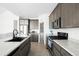 Bright kitchen features gray cabinets, stainless steel appliances, quartz counters, and a rustic pantry door at 720 Remington Dr, Hudson, CO 80642