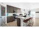 Bright kitchen with gray cabinets, quartz counters, large island with seating, and stainless steel appliances at 720 Remington Dr, Hudson, CO 80642