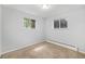 This carpeted bedroom features neutral colors, baseboard heaters and views of mature trees at 387 Tucson St, Aurora, CO 80011