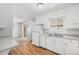 Bright kitchen with stainless steel sink, white cabinets, and vinyl flooring at 387 Tucson St, Aurora, CO 80011