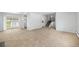 Open living room with plush carpet, sliding glass doors, and stairs leading to the second floor at 387 Tucson St, Aurora, CO 80011