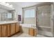 Bathroom featuring a soaking tub, a glass shower, and wooden cabinets at 4143 Eagle Ridge Way, Castle Rock, CO 80104