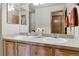 Well-lit bathroom with double sinks, light wood cabinets, and a large mirror at 4143 Eagle Ridge Way, Castle Rock, CO 80104