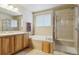 Bathroom with a double sink, soaking tub, and glass shower at 4143 Eagle Ridge Way, Castle Rock, CO 80104