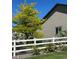 Tan siding on the exterior of the house with a white fence, roses, and greenery at 4143 Eagle Ridge Way, Castle Rock, CO 80104