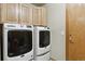 Laundry room with side-by-side washing machines, cabinets, and a door to outside at 4143 Eagle Ridge Way, Castle Rock, CO 80104