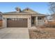 Brick home with a two-car garage and a well-maintained lawn at 20351 E Lasalle Pl, Aurora, CO 80013