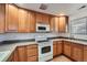 Bright kitchen with oak cabinets, white appliances, and a tiled floor at 20351 E Lasalle Pl, Aurora, CO 80013