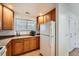 Kitchen features oak cabinets, white appliances, and a view into the dining area at 20351 E Lasalle Pl, Aurora, CO 80013