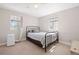 Cozy bedroom featuring neutral walls, carpet, and a metal-framed bed with a window for natural light at 1343 Valentia St, Denver, CO 80220
