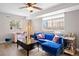 Sunlit living room featuring plush blue sofa, accent seating, stylish decor, and large windows create a cozy and inviting atmosphere at 1343 Valentia St, Denver, CO 80220
