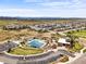 Overhead shot capturing the community pool, clubhouse, parking, and homes, against a backdrop of distant mountains at 14102 Night Owl Ln, Parker, CO 80134