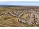 An aerial view of a residential area with open spaces, walking trails, and mountain vistas in the distance at 14102 Night Owl Ln, Parker, CO 80134