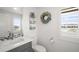 Well-lit half bathroom with modern fixtures, decorative wreath, and convenient storage shelves at 14102 Night Owl Ln, Parker, CO 80134