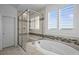 Luxurious bathroom featuring a soaking tub, glass enclosed shower, and tiled walls at 14102 Night Owl Ln, Parker, CO 80134