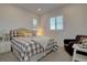 Cozy bedroom featuring a comfortable bed with decorative pillows, a reading chair, and natural light at 14102 Night Owl Ln, Parker, CO 80134
