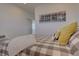 Bright bedroom with a plaid bedspread, decorative pillows, and natural light at 14102 Night Owl Ln, Parker, CO 80134