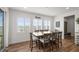 Bright dining area with a large wooden table, seating for eight, and scenic views through shuttered windows at 14102 Night Owl Ln, Parker, CO 80134