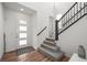 Bright entryway with hardwood floors, staircase with black railing, and modern front door at 14102 Night Owl Ln, Parker, CO 80134