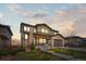 Two-story home featuring a manicured lawn, stone accents, and a covered front porch with seating at 14102 Night Owl Ln, Parker, CO 80134