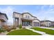 Charming home featuring stone accents, manicured lawn, and covered front porch with seating area at 14102 Night Owl Ln, Parker, CO 80134