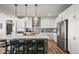 Modern kitchen with white cabinets, stainless steel appliances, pendant lights and large center island at 14102 Night Owl Ln, Parker, CO 80134